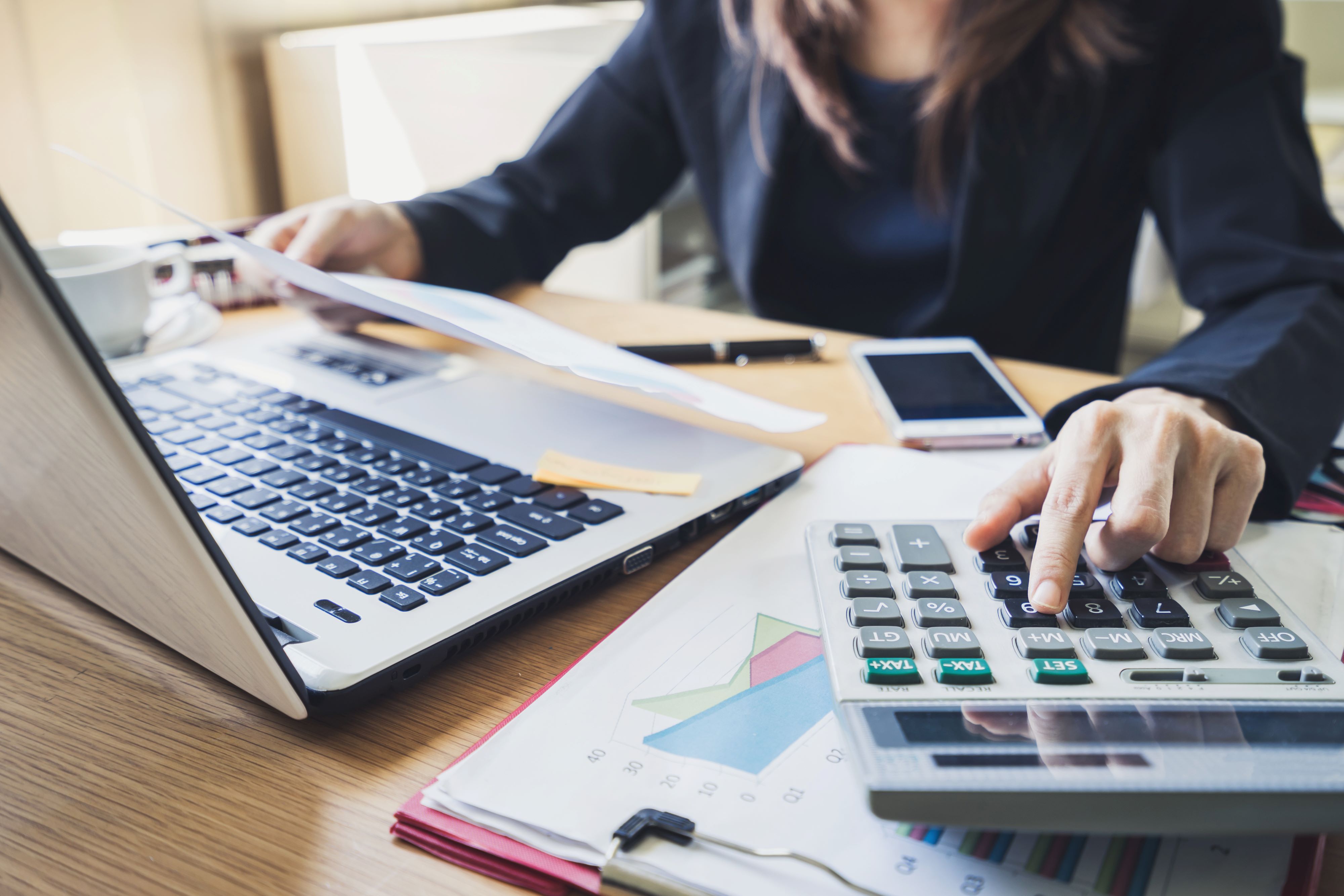 Businessperson with laptop and calculator