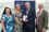 Four smiling people in front of an awards banner in a brightly lit room