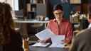 Female businesswoman reviewing documents in an office, with highlighters and pens next to her