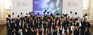 Image of individuals in graduation hats and gowns throwing hats in the air at Chartered Institute graduation ceremony
