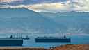 Freight ships idling in the Red Sea, with mountains in the background